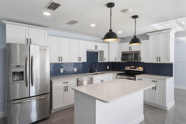 kitchen with pendant lighting, sink, white cabinets, and stainless steel appliances