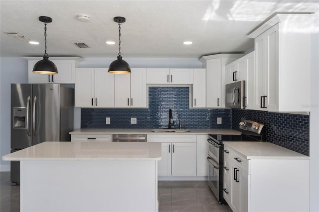 kitchen featuring white cabinets, decorative light fixtures, stainless steel appliances, and sink