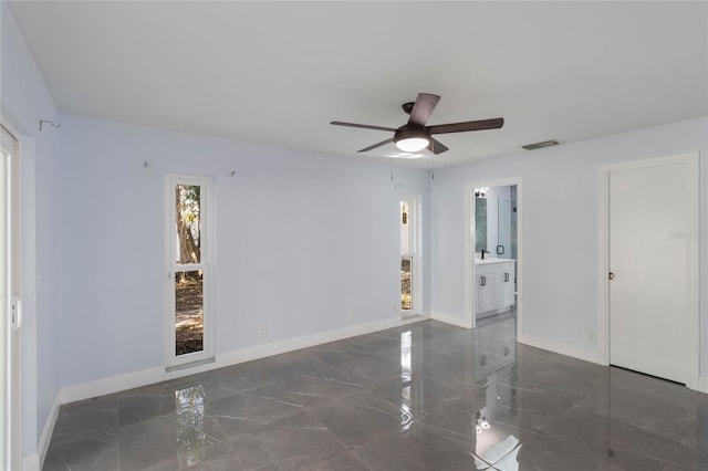 unfurnished room featuring ceiling fan and sink