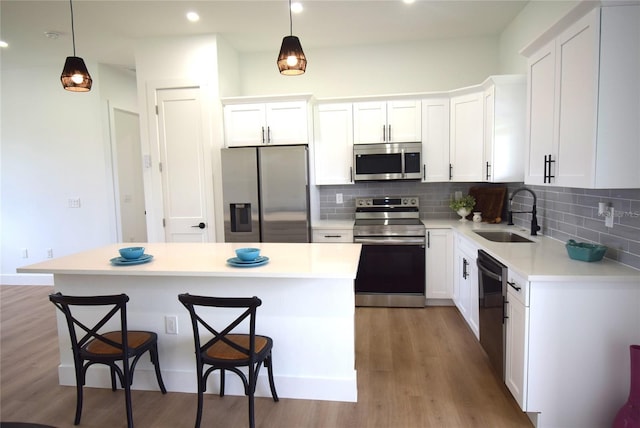 kitchen featuring a center island, white cabinetry, sink, and appliances with stainless steel finishes