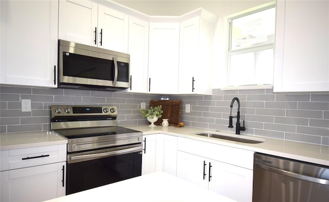 kitchen with sink, white cabinetry, stainless steel appliances, and tasteful backsplash