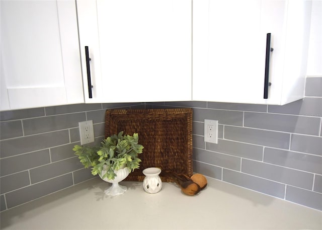 room details featuring backsplash and white cabinetry