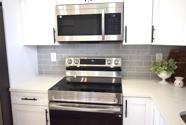 kitchen with decorative backsplash, white cabinetry, and stainless steel appliances