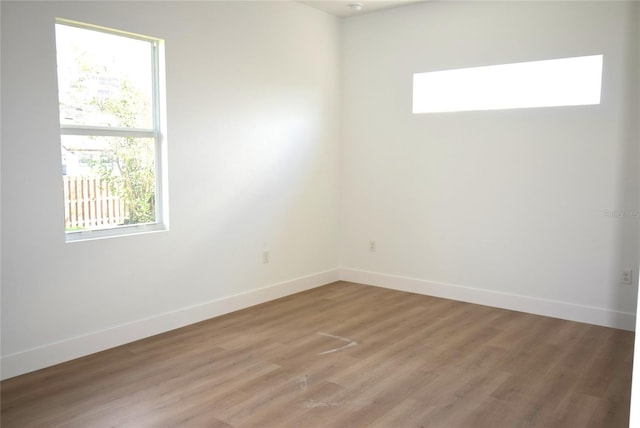 spare room with a wealth of natural light and hardwood / wood-style floors