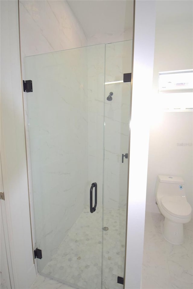 bathroom with toilet and a shower with shower door