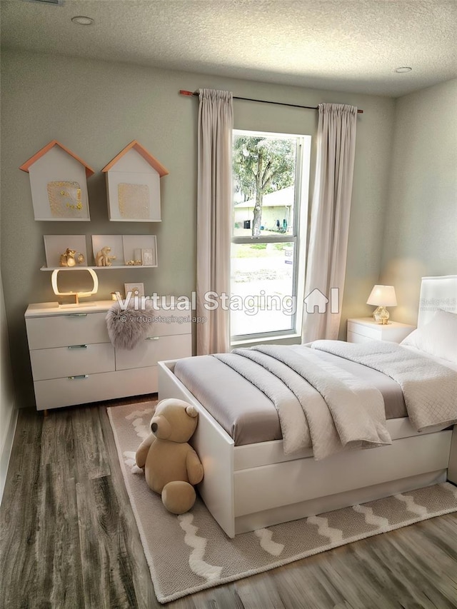 bedroom featuring a textured ceiling and dark wood-type flooring