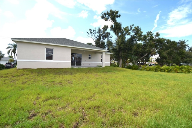 rear view of house featuring a yard