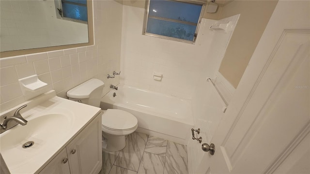 full bathroom with tiled shower / bath, vanity, toilet, and tile walls