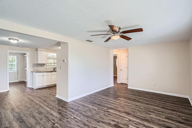 unfurnished room with dark hardwood / wood-style flooring, ceiling fan, sink, and a textured ceiling