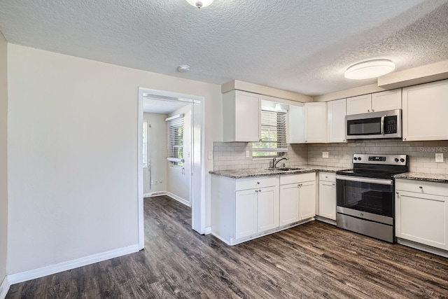 kitchen with stainless steel appliances, white cabinetry, sink, and dark hardwood / wood-style floors