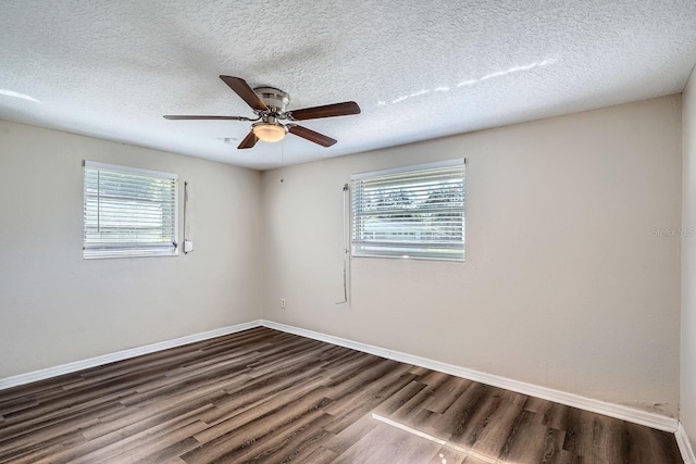 spare room with dark hardwood / wood-style flooring, ceiling fan, plenty of natural light, and a textured ceiling