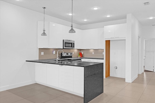 kitchen featuring sink, stainless steel appliances, kitchen peninsula, pendant lighting, and white cabinets