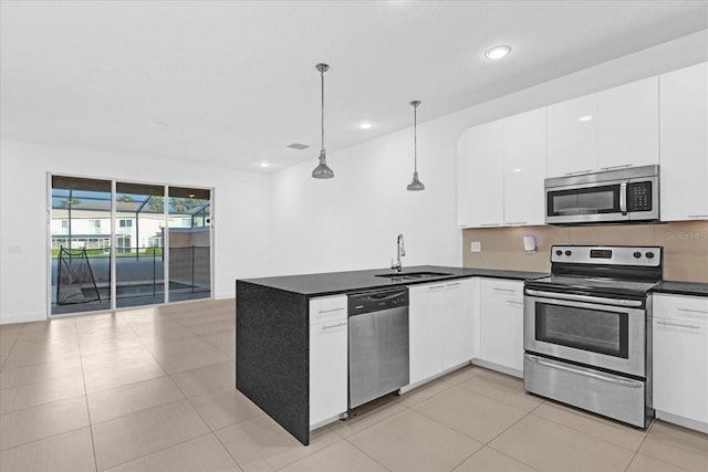 kitchen featuring white cabinets, decorative light fixtures, sink, and stainless steel appliances