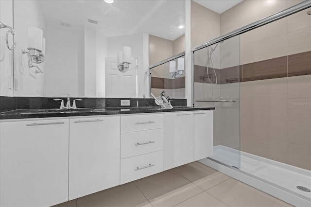 bathroom featuring tile patterned floors, vanity, and a shower with door