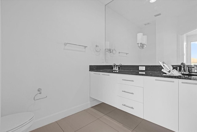 bathroom featuring tile patterned flooring, vanity, and toilet