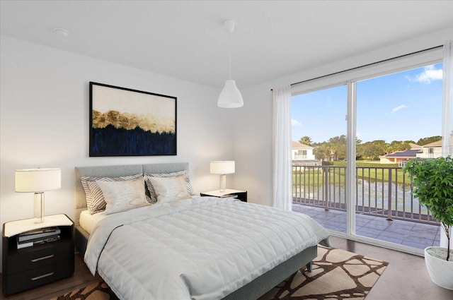 bedroom featuring access to outside and a water view