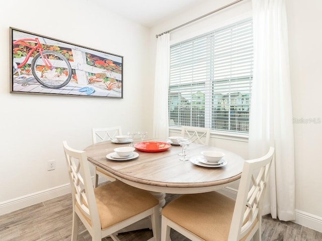 dining area featuring baseboards and light wood-style floors