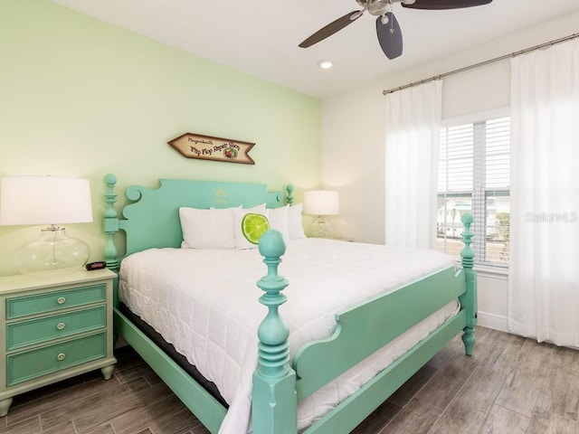 bedroom with ceiling fan, wood finished floors, and baseboards