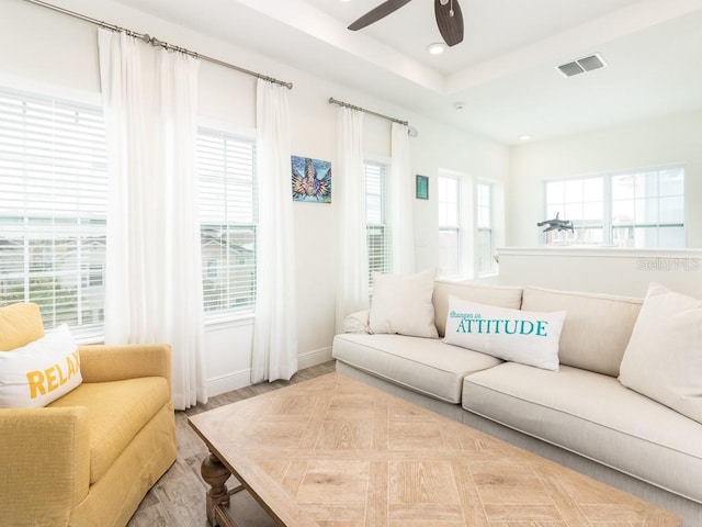 living room with recessed lighting, a raised ceiling, visible vents, a ceiling fan, and wood finished floors