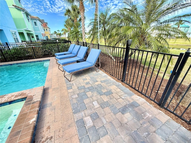 view of swimming pool featuring a patio, fence, and a fenced in pool