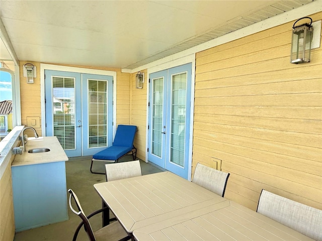 exterior space with outdoor dining area, a sink, and french doors