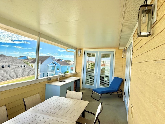 balcony featuring french doors, a sink, and outdoor dining area