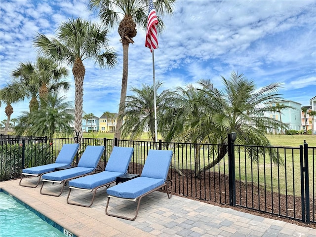 view of patio / terrace with a community pool and fence