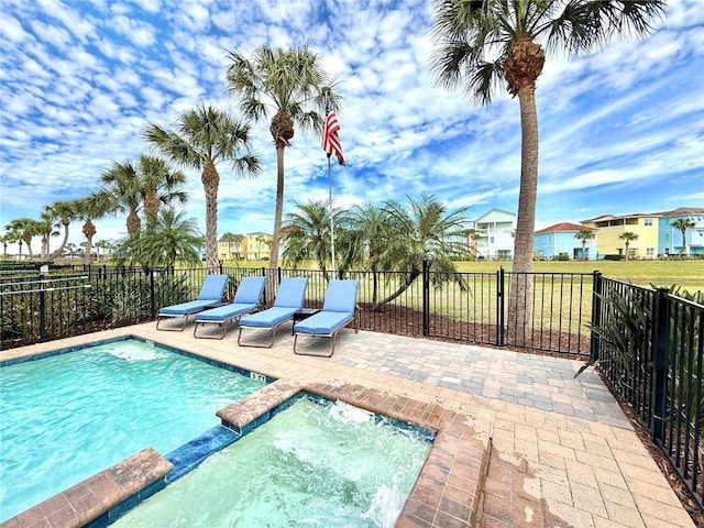 view of pool featuring a pool with connected hot tub, fence, and a patio