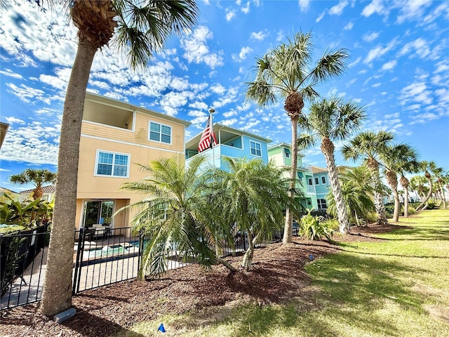 back of property with a fenced in pool, fence, a yard, a patio area, and stucco siding