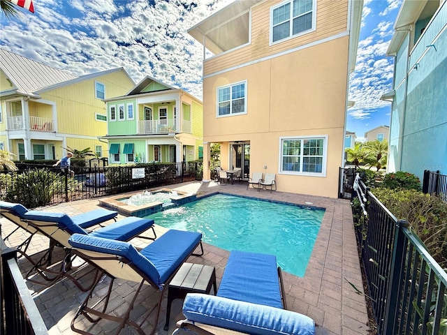 view of swimming pool featuring a patio, fence, and a pool with connected hot tub