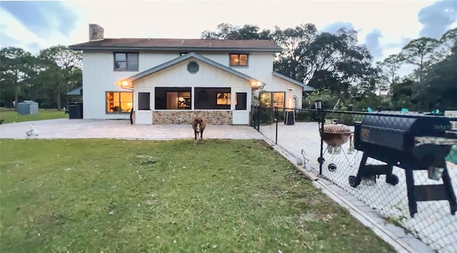 back of house with a lawn and a patio area