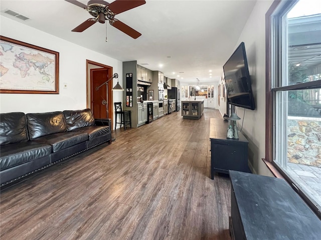 living room with dark hardwood / wood-style floors and ceiling fan