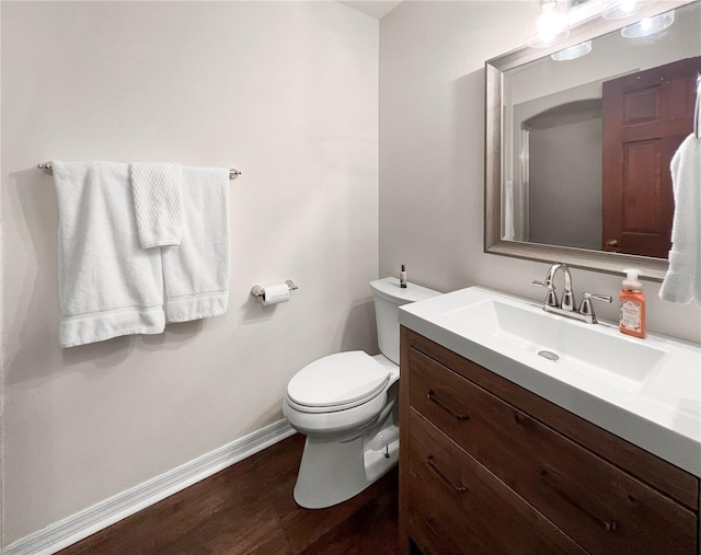 bathroom featuring vanity, hardwood / wood-style flooring, and toilet