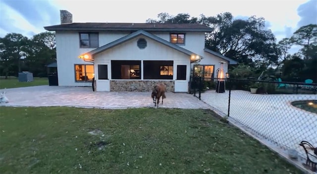 back of property with a lawn and a patio area