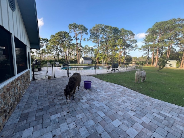 surrounding community with a swimming pool, a lawn, and a patio