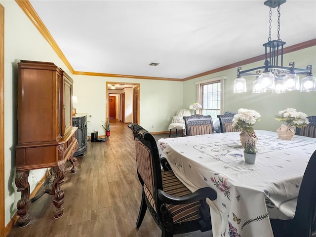 dining area featuring hardwood / wood-style flooring and ornamental molding