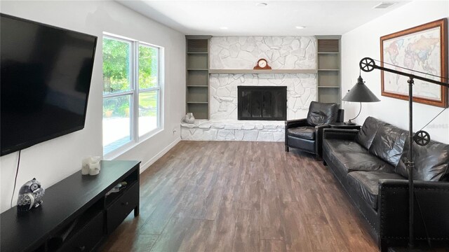 6885 Orchid Tree Dr, Grant, FL 32949 - living area featuring wood finished floors, a stone fireplace, and baseboards