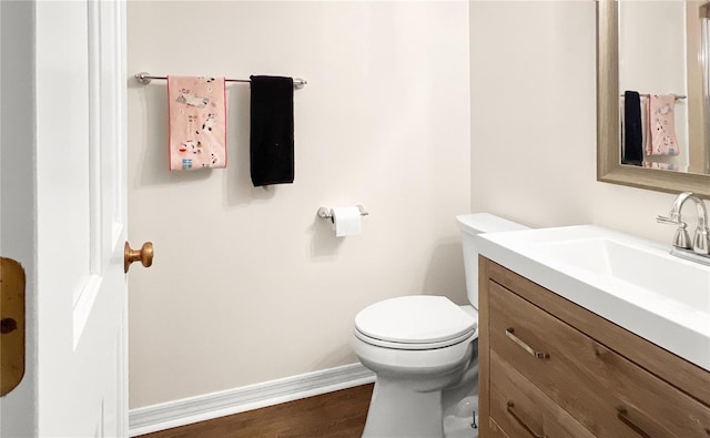 6885 Orchid Tree Dr, Grant, FL 32949 - half bath with vanity, toilet, baseboards, and wood finished floors