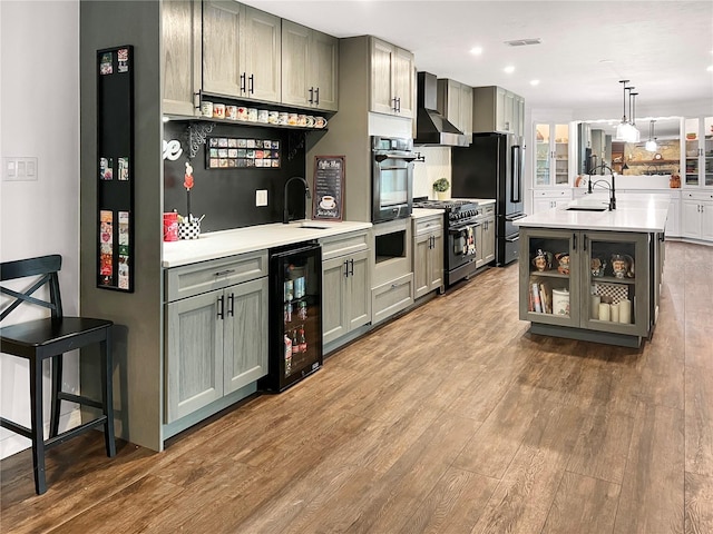 6885 Orchid Tree Dr, Grant, FL 32949 - kitchen featuring beverage cooler, appliances with stainless steel finishes, wall chimney range hood, a sink, and light countertops