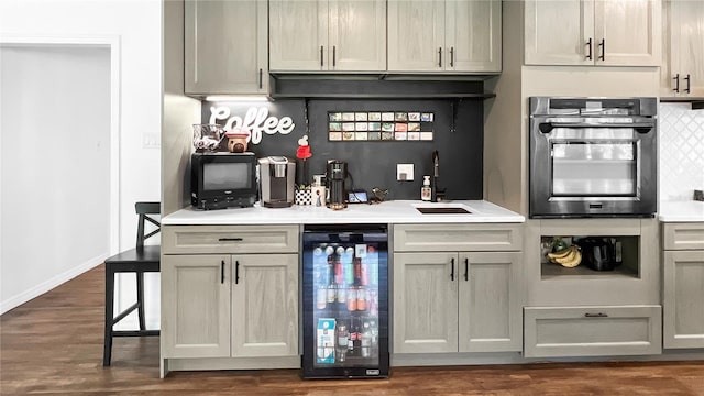 6885 Orchid Tree Dr, Grant, FL 32949 - indoor wet bar featuring oven, wine cooler, dark wood-type flooring, backsplash, and baseboards