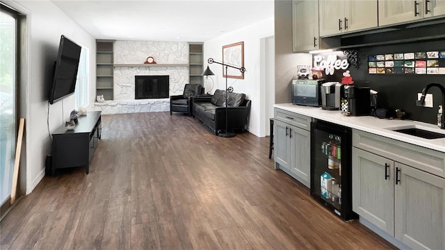 6885 Orchid Tree Dr, Grant, FL 32949 - bar area featuring a sink, dark wood-style flooring, wine cooler, and a fireplace