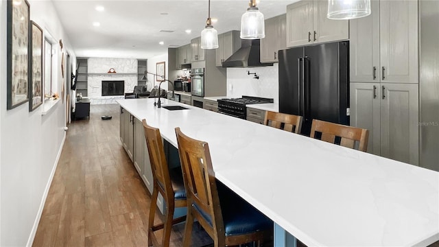 6885 Orchid Tree Dr, Grant, FL 32949 - kitchen with a sink, freestanding refrigerator, gas stove, wall chimney exhaust hood, and baseboards