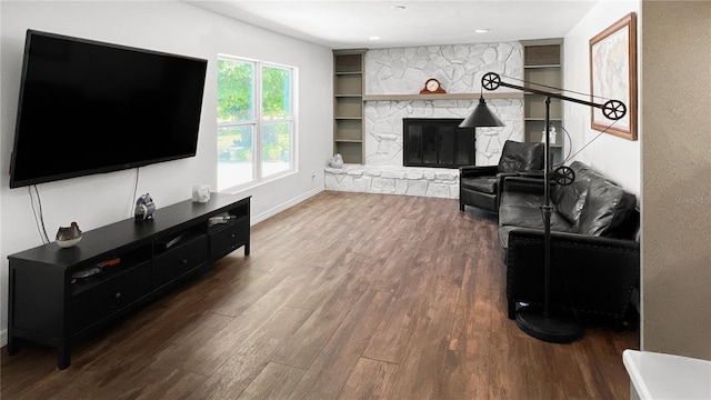 6885 Orchid Tree Dr, Grant, FL 32949 - living room with wood finished floors, a stone fireplace, baseboards, and built in features