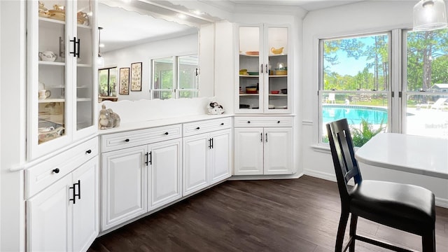 6885 Orchid Tree Dr, Grant, FL 32949 - kitchen with dark wood-style flooring, glass insert cabinets, white cabinetry, and baseboards