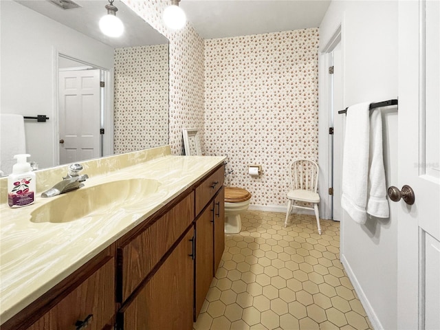 6885 Orchid Tree Dr, Grant, FL 32949 - bathroom with toilet, vanity, baseboards, tile patterned flooring, and wallpapered walls