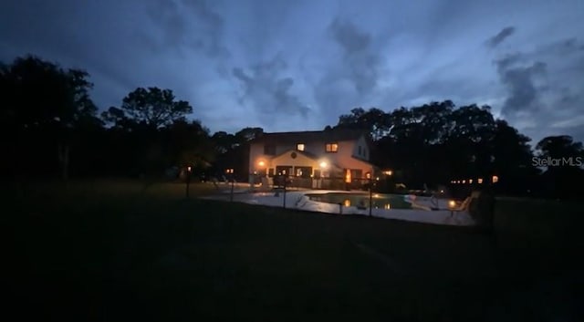 6885 Orchid Tree Dr, Grant, FL 32949 - back of house at night featuring a patio area and a yard