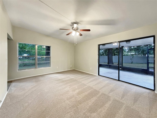 carpeted spare room featuring ceiling fan and vaulted ceiling