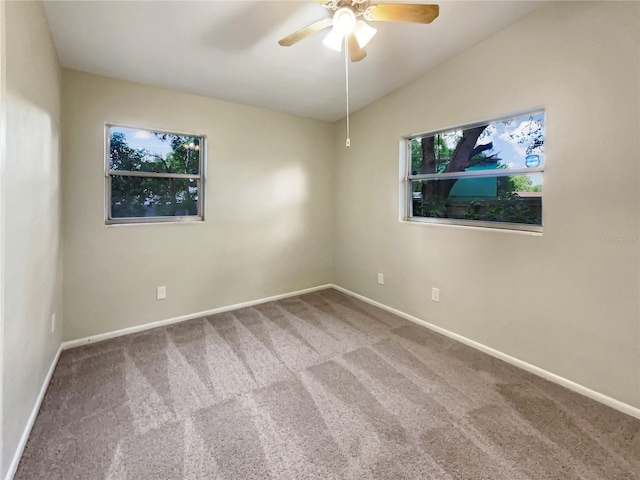 carpeted spare room featuring ceiling fan