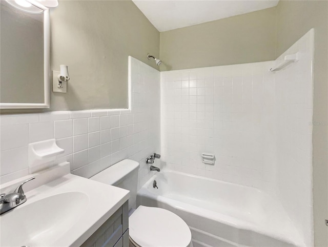 full bathroom with tiled shower / bath combo, toilet, tile walls, and vanity