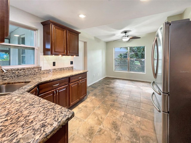 kitchen with decorative backsplash, stainless steel refrigerator, ceiling fan, and sink